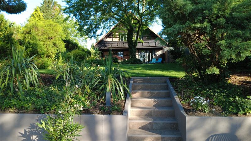 Hausansicht mit Garten und Terrasse zum See hin