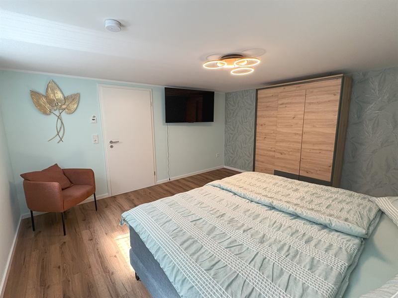 Schlafzimmer 4 im Untergeschoss mit Doppelbett und TV